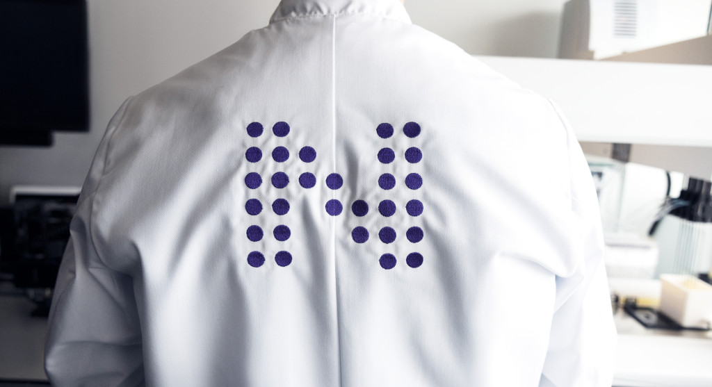 Laboratory specialist wearing a lab coat with Nightingale Health logo in the back.