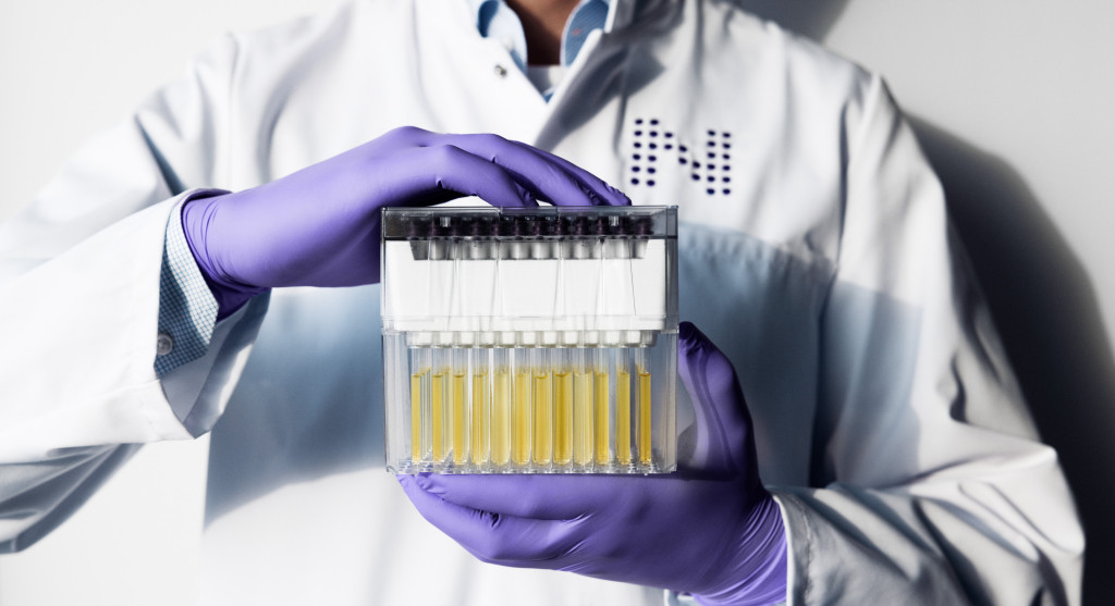Nightingale Health laboratory specialist holding a sample rack with both hands.